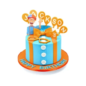 Blippi-themed birthday cake with blue buttercream, orange bow and suspenders, fondant glasses, and balloon toppers spelling “JACKSON” with a number 3 star balloon.