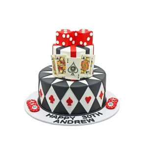 Casino themed birthday cake with playing cards, red dice, poker chips, and black-and-white diamond pattern.