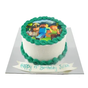Minecraft-themed 13th birthday cake by Amarantos Cakes featuring white buttercream, green piping, an edible image of Minecraft characters, and a personalised “Happy 13th Birthday Julian” message in blue-green icing.