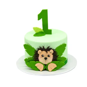 Light green jungle-themed first birthday cake with fondant lion face, leafy accents, and large number 1 topper.