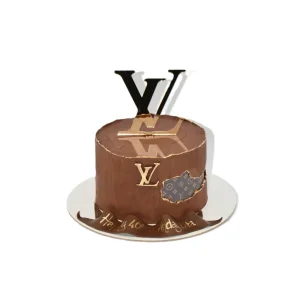 Chocolate Louis Vuitton-themed birthday cake with gold LV topper, monogram patch detail, and “Happy 40th Birthday Lira” message.