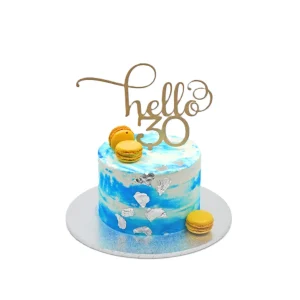 Blue and white marbled birthday cake with silver foil accents, yellow macarons, and “hello 30” topper.