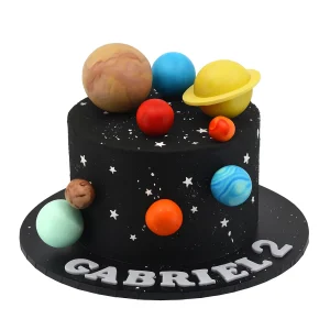 Space-themed 2nd birthday cake by Amarantos Cakes featuring black buttercream with star-like specks, edible planets including Saturn and Earth, and a personalised ‘Gabriel 2’ message in white lettering.