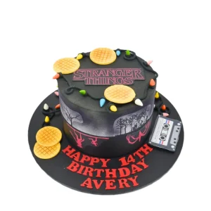 Stranger Things-themed birthday cake featuring edible waffles, cassette tape, Christmas lights, and eerie Upside Down details. A bold, personalised centrepiece for fans of the hit Netflix series.